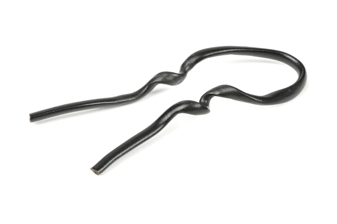 A black plastic coated wire twist tie on a white background